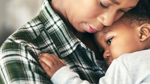 Black mother hugging toddler child