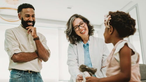 Black father with young daughter at doctor's office