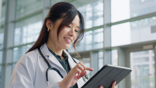 Female Asian doctor holding a tablet