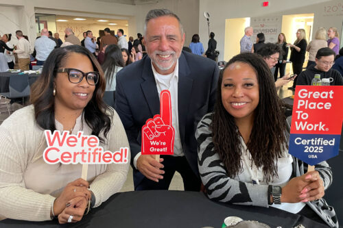Group of Baylor Genetics employees holding Great Place to Work signs
